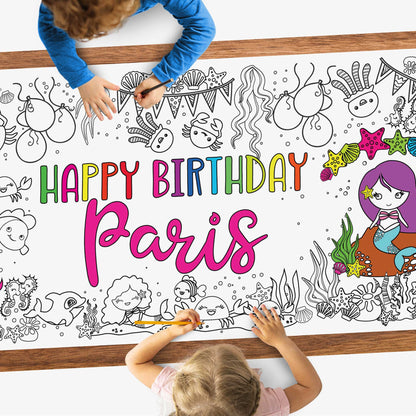 kids coloring a poster on a table